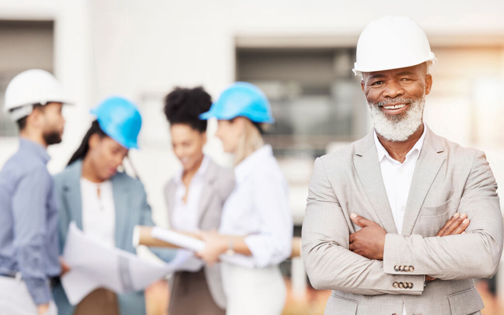 Architecture, construction and portrait of senior black man with team for building site, engineering